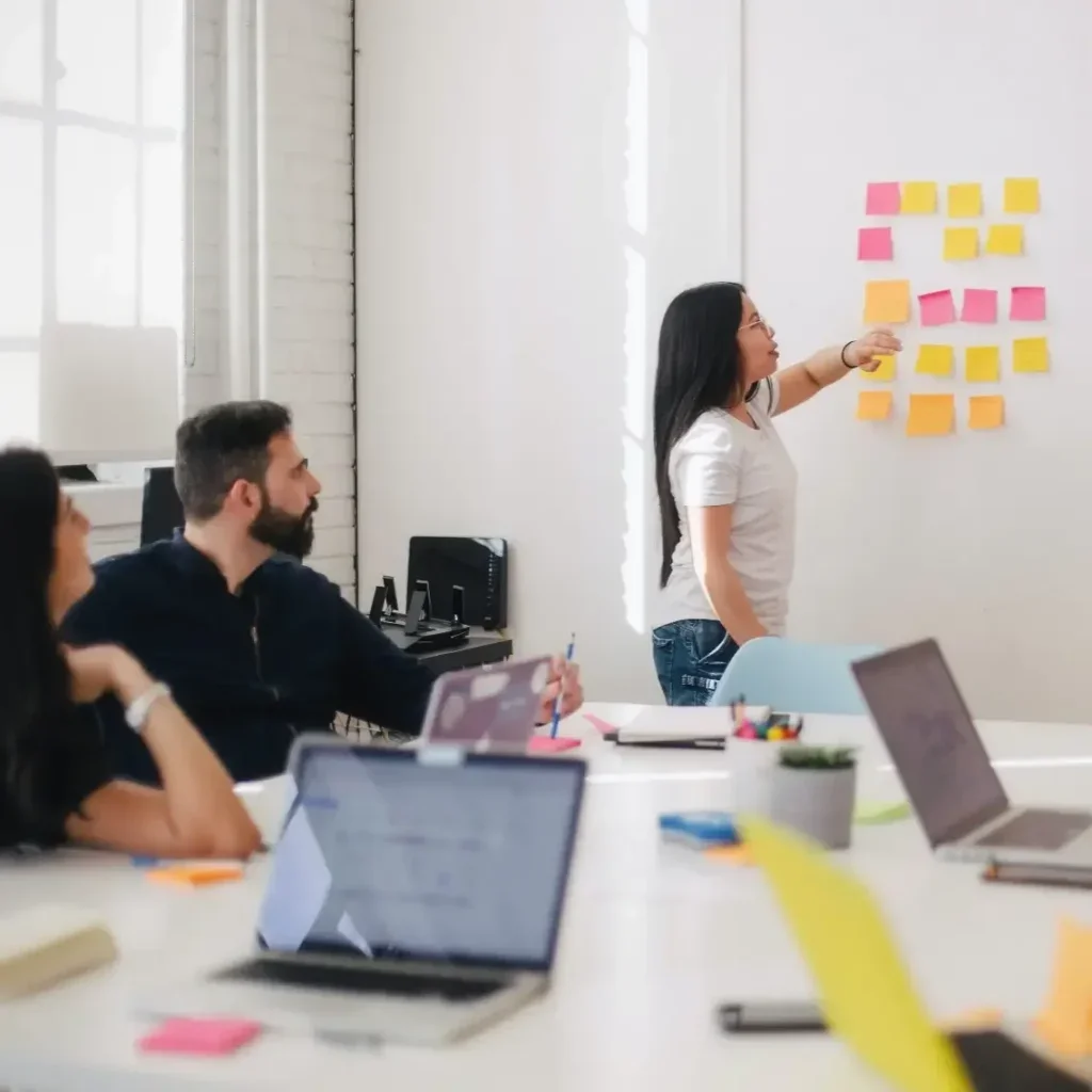 People in a conference room mapping out their businesses processes on a whiteboard.