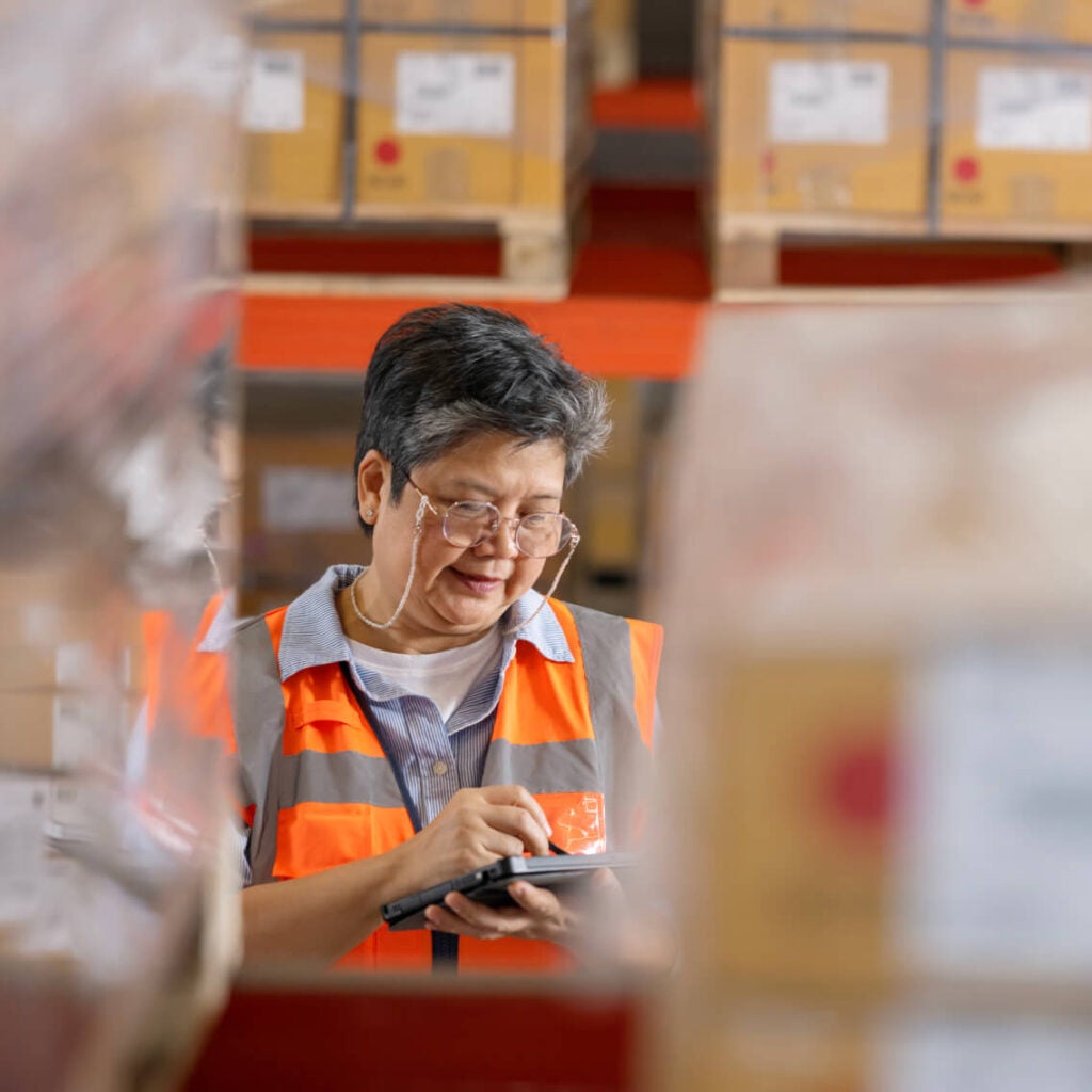 Person working on a tablet in a warehouse.