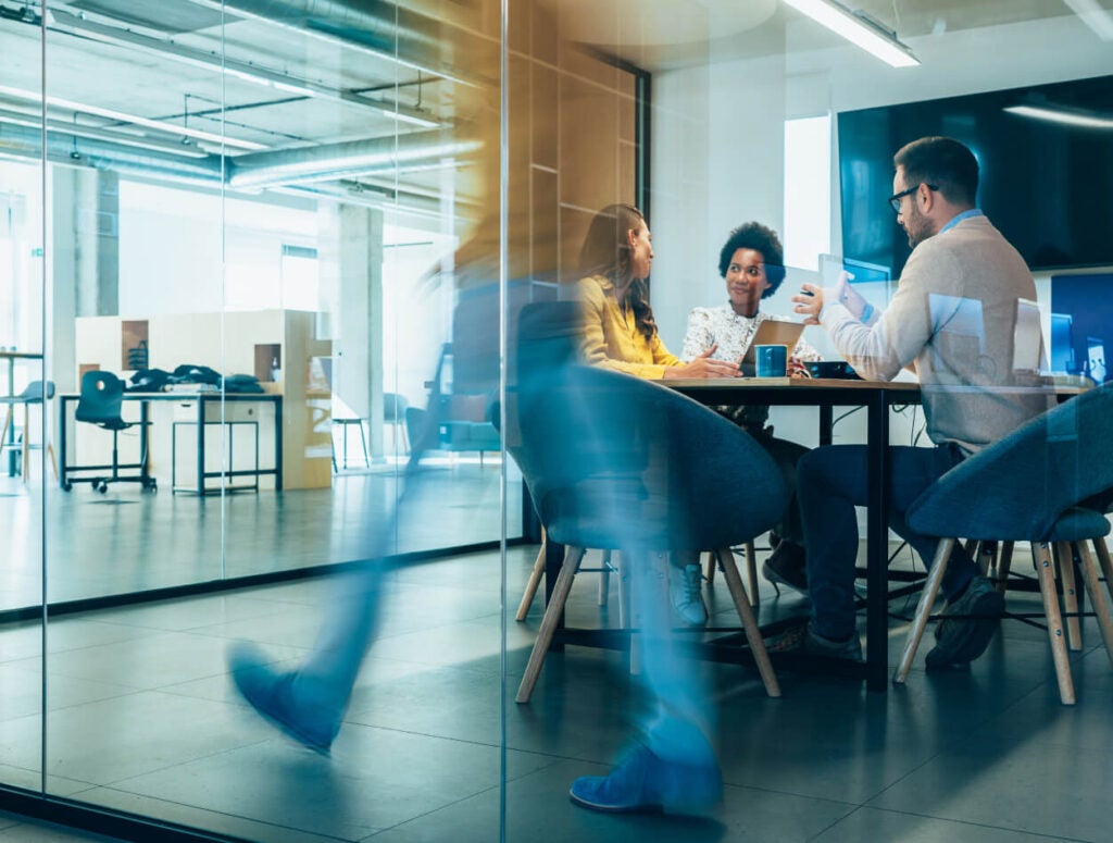 People walking across board room meeting