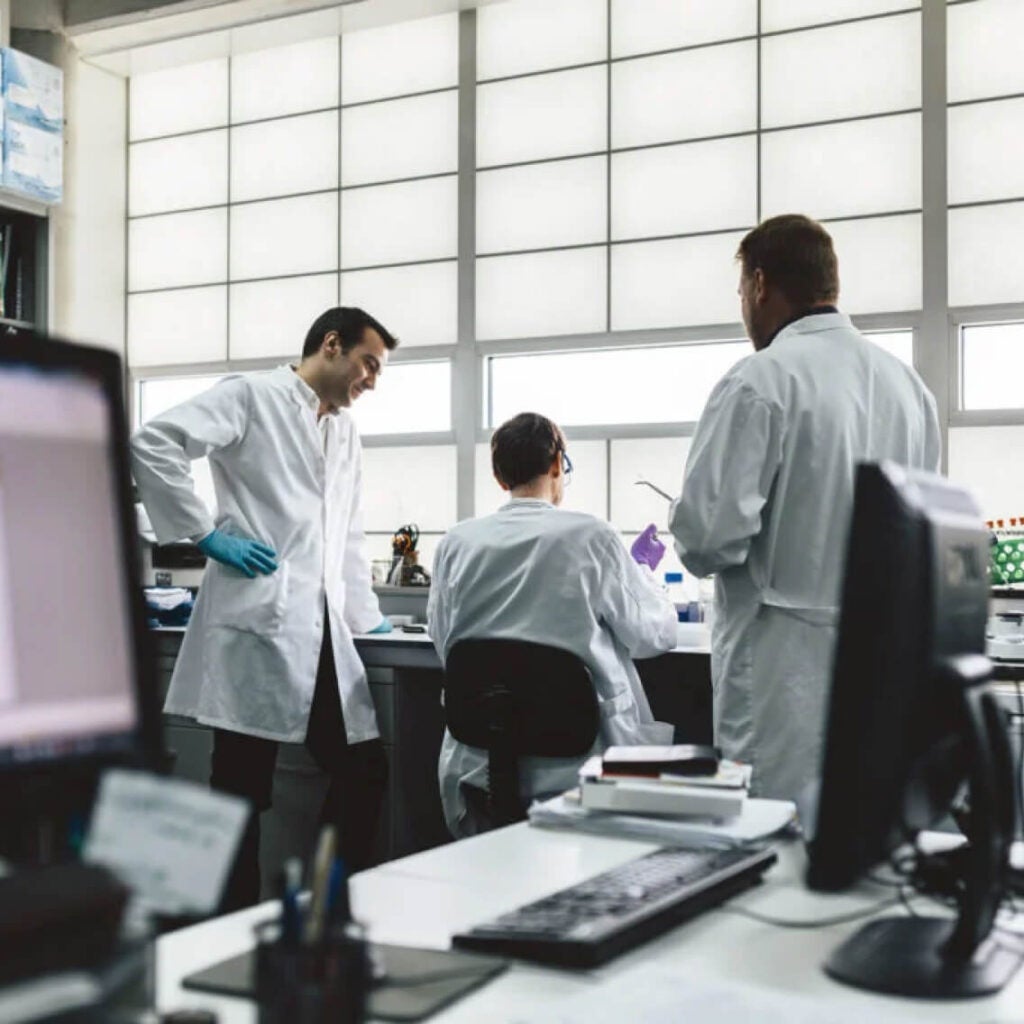 Doctors standing around a desk.