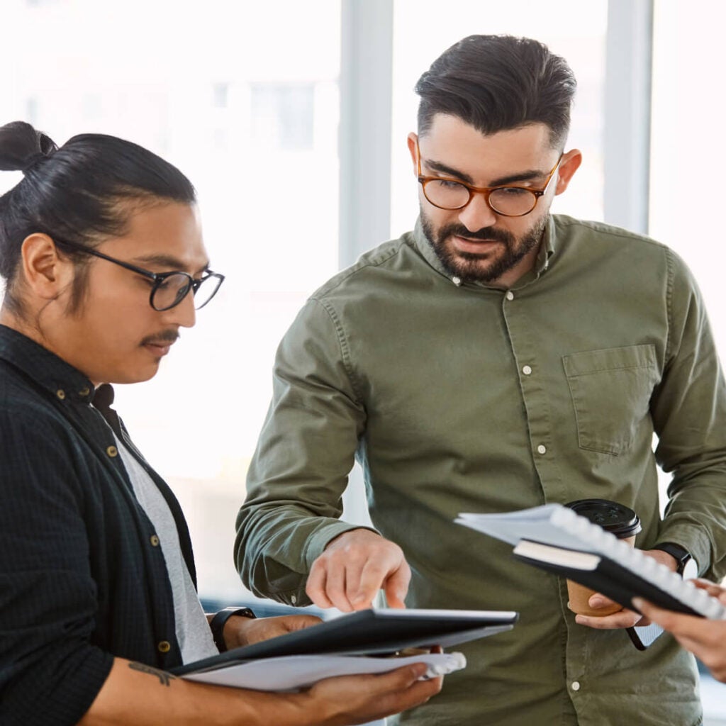 Two men discussing work on a tablet